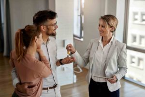 what makes a good real estate agent; agent handing keys to couple
